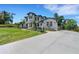 Stunning view of the home's front exterior, long driveway, lush lawn, and mature landscaping at 2645 Delphi Hills Ct, Lakeland, FL 33812
