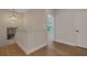 Upstairs hallway featuring hardwood floors, neutral paint, stylish light fixture and an inviting view into adjacent room at 2645 Delphi Hills Ct, Lakeland, FL 33812