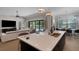 Kitchen island with stainless steel sink and seating, open to living room and pool views at 2645 Delphi Hills Ct, Lakeland, FL 33812