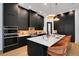 Modern kitchen featuring a large island with white countertop, black cabinets, and stainless steel appliances at 2645 Delphi Hills Ct, Lakeland, FL 33812