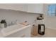 Bright laundry room with white cabinetry, sink, and a window for natural light at 2645 Delphi Hills Ct, Lakeland, FL 33812