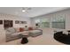 Relaxing living room features a sectional sofa, large windows, and modern decor at 2645 Delphi Hills Ct, Lakeland, FL 33812
