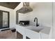 Outdoor kitchen has stainless steel appliances, a sink, and a range hood with dark wood covering the ceiling at 2645 Delphi Hills Ct, Lakeland, FL 33812