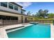Swimming pool surrounded by a dark safety fence and the back of the modern two-story home at 2645 Delphi Hills Ct, Lakeland, FL 33812