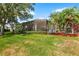 This screened back porch provides outdoor living space with mature landscaping, lush lawn, and a beautiful bench at 2820 Prestwick Dr, Lakeland, FL 33803
