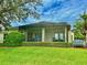 This screened back porch offers outdoor living space with mature landscaping, including a beautiful bench and lush green lawn at 2820 Prestwick Dr, Lakeland, FL 33803