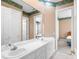 Bathroom featuring dual sinks, a large mirror, tile flooring and a floral wallpaper border at 2820 Prestwick Dr, Lakeland, FL 33803