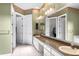 Bathroom with dual sink vanity, large mirror, and a view of a walk-in closet at 2820 Prestwick Dr, Lakeland, FL 33803