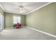 Spacious bedroom with neutral carpet, bright windows, and a ceiling fan at 2820 Prestwick Dr, Lakeland, FL 33803