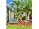 Inviting exterior features a bench seat, lush palm trees, and colorful foliage at 2820 Prestwick Dr, Lakeland, FL 33803