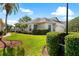Beautiful home exterior featuring manicured landscaping, lush lawn, and a classic design with mature palm trees at 2820 Prestwick Dr, Lakeland, FL 33803