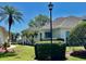 Beautiful home exterior featuring lush landscaping, a well-kept lawn, and a classic design with mature palm trees at 2820 Prestwick Dr, Lakeland, FL 33803