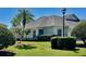 Charming exterior view featuring manicured landscaping, a well-maintained lawn, and a classic design with palm trees at 2820 Prestwick Dr, Lakeland, FL 33803