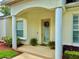 Inviting front door featuring a decorative wreath and a covered porch area with decorative columns and manicured landscaping at 2820 Prestwick Dr, Lakeland, FL 33803