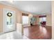 Spacious living room with hardwood flooring, a chandelier, natural light, and an entryway featuring a decorative wreath at 2820 Prestwick Dr, Lakeland, FL 33803