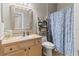 Bathroom featuring single sink vanity, toilet, and walk-in shower with blue patterned curtain at 3187 Bellflower Way, Lakeland, FL 33811