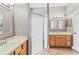 Bathroom featuring double sink vanities, walk-in shower with glass doors, and tile flooring at 3187 Bellflower Way, Lakeland, FL 33811