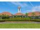 Beautiful clubhouse featuring manicured landscaping, a brick wall, and a charming bell tower at 3187 Bellflower Way, Lakeland, FL 33811