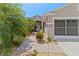 Inviting home exterior with a brick walkway, lush landscaping, and a screened two-car garage at 3187 Bellflower Way, Lakeland, FL 33811