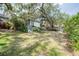 Spacious backyard featuring mature trees, lush landscaping, and a charming home exterior at 319 Shadow Moss Ct # 319, Lakeland, FL 33813