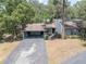 Charming single Gathering home featuring a two-car carport, mature landscaping, and a welcoming walkway to the front door at 319 Shadow Moss Ct # 319, Lakeland, FL 33813