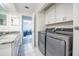 Convenient laundry room featuring modern washer and dryer, storage cabinets, and a granite countertop vanity at 319 Shadow Moss Ct # 319, Lakeland, FL 33813