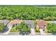 Aerial view of homes backing up to wooded area, with manicured lawns and mature landscaping at 3252 Bellflower Way, Lakeland, FL 33811