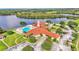 Aerial view of community clubhouse with pool, gazebo, parking, and lake, all surrounded by lush greenery at 3252 Bellflower Way, Lakeland, FL 33811