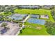 Aerial view showcasing tennis courts, pickleball courts, a basketball court, and a playground in a lush community at 3252 Bellflower Way, Lakeland, FL 33811