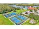 Aerial view of community courts, playground, pool and community center by a lake at 3252 Bellflower Way, Lakeland, FL 33811