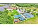 Aerial view showcasing tennis courts, pickleball court, basketball court and playground surrounded by lush green landscape at 3252 Bellflower Way, Lakeland, FL 33811
