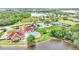 Aerial view of the clubhouse, community pool, gazebo, tennis courts, and lake surrounded by trees at 3252 Bellflower Way, Lakeland, FL 33811