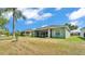Backyard featuring a well-maintained lawn, mature trees, and screened-in porch providing a serene outdoor space at 3252 Bellflower Way, Lakeland, FL 33811