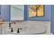Close up of white soaking tub, window and blinds, and bronze hardware at 3252 Bellflower Way, Lakeland, FL 33811