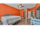 Cozy bedroom with orange walls, wood flooring, and connecting doorway at 3252 Bellflower Way, Lakeland, FL 33811
