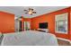 Cozy bedroom with orange walls, wood flooring, ceiling fan and large windows at 3252 Bellflower Way, Lakeland, FL 33811