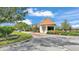 Exterior view of guard house entrance featuring lush green landscaping and a private, gated community at 3252 Bellflower Way, Lakeland, FL 33811
