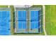 Aerial view of two blue outdoor pickleball courts with green surrounds and a black fence at 3252 Bellflower Way, Lakeland, FL 33811