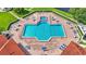 Aerial view of a large community swimming pool with a hot tub and lounge chairs on a brick patio at 3252 Bellflower Way, Lakeland, FL 33811