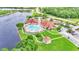 Aerial view of community pool, clubhouse, gazebo, parking, and lake, all surrounded by lush greenery at 3252 Bellflower Way, Lakeland, FL 33811