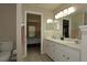 Bright bathroom featuring a double vanity, well-lit mirrors, and an open doorway to the bedroom at 3359 Sanoma Dr, Lakeland, FL 33811