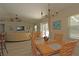 Open-concept dining room with a wooden table set for four, seamlessly connected to the living area and the pool at 3359 Sanoma Dr, Lakeland, FL 33811