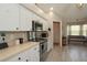 Well-lit kitchen boasts white cabinets, stainless steel appliances, wood look flooring, and a sunny breakfast nook at 3359 Sanoma Dr, Lakeland, FL 33811