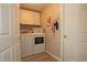 Functional laundry room featuring white washer and dryer, storage cabinets, and wood look flooring at 3359 Sanoma Dr, Lakeland, FL 33811