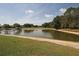 Picturesque pond within the community, bordered by grass and trees at 3359 Sanoma Dr, Lakeland, FL 33811