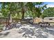 A shaded backyard featuring a patio, furniture, grill, and mature trees, perfect for outdoor living at 3805 Gaines Dr, Winter Haven, FL 33884