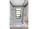 Clean bathroom with tile walls, a bathtub, and natural light at 3805 Gaines Dr, Winter Haven, FL 33884