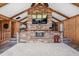 Comfortable living room with a brick fireplace, vaulted ceilings, wood paneling, and plush carpet, creating a cozy atmosphere at 3805 Gaines Dr, Winter Haven, FL 33884