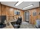 Wood paneled office with a desk, door and large windows for natural light at 3805 Gaines Dr, Winter Haven, FL 33884