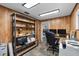Home office featuring wood paneled walls, shelving, and a view of the backyard at 3805 Gaines Dr, Winter Haven, FL 33884